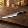 Shokutsū Gyuto Kokkekniv på et bord i mørk eg