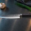Shokutsū gyuto kokkekniv på et kokkebord i rustfrit stål